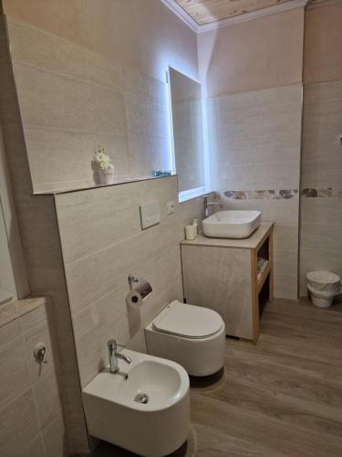 a bathroom with a white toilet and a sink at La Casa di Mimmo in Gradara