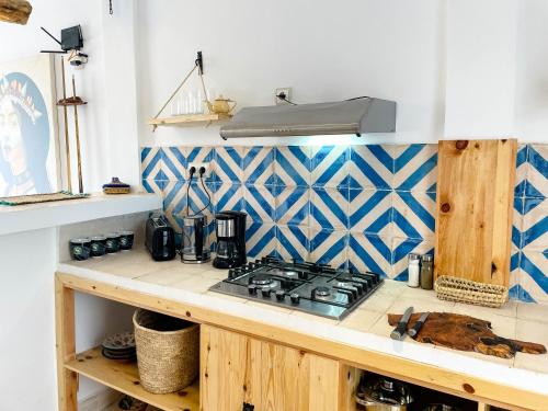 a kitchen with a stove and a counter top at Taouarguit Guest House in Imsouane