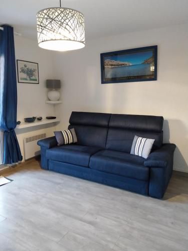 un salon avec un canapé bleu dans une pièce dans l'établissement T1 Lavandou La favière en rez de jardin bord de mer, à Bormes-les-Mimosas