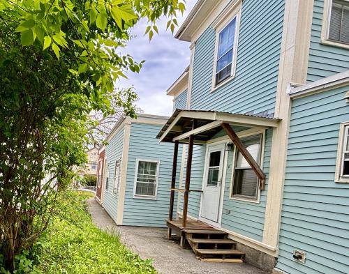 a blue house with a bench on the side of it at Traveler’s Den in Medford in Medford