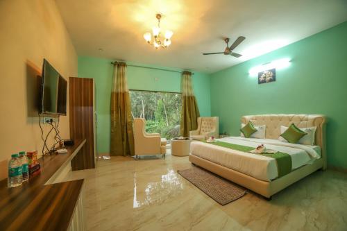 a bedroom with a bed and a living room at Rain Rock Villa in Yercaud