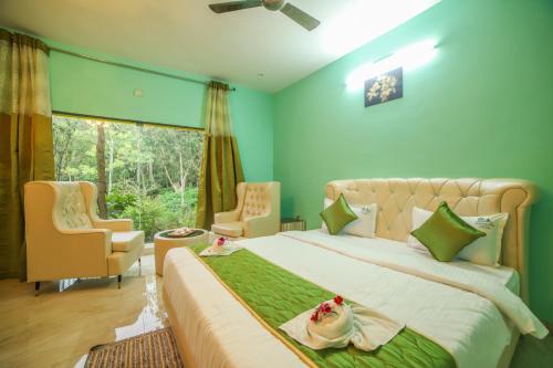 a bedroom with a large bed with green walls at Rain Rock Villa in Yercaud