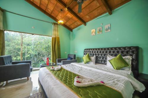 a bedroom with a large bed with green walls at Rain Rock Villa in Yercaud