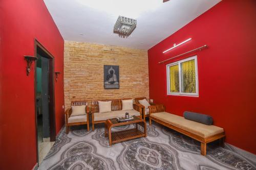 a living room with red walls and couches at Rain Rock Villa in Yercaud