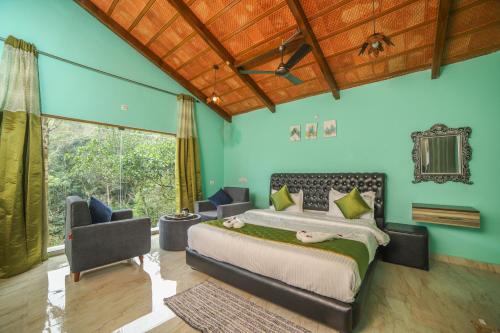 a bedroom with a bed and a large window at Rain Rock Villa in Yercaud