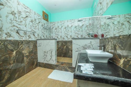 a bathroom with a sink and a mirror at Rain Rock Villa in Yercaud