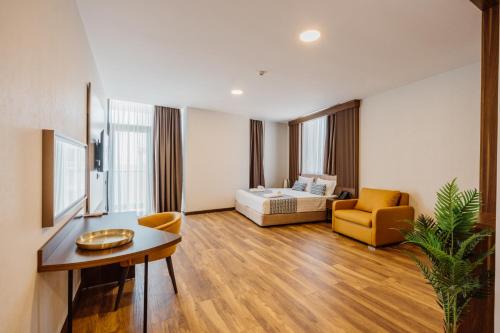 a room with a bed and a couch and a table at Hotel Navi in Batumi