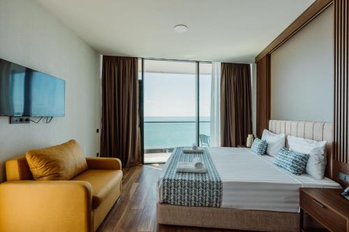 a hotel room with a large bed and a couch at Apart Hotel NAVI in Batumi