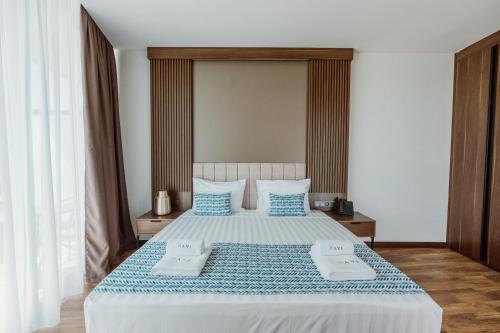 a bedroom with a large bed with blue and white sheets at Hotel Navi in Batumi
