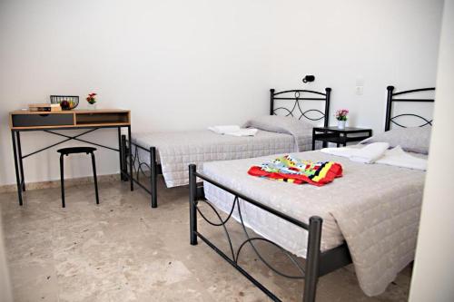 a room with three beds and a desk and a table at El Verano in Kardamaina