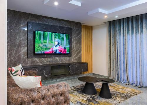 Una sala de estar con un sofá y un televisor en una pared. en FB-Canatal Luxury Apartments, en Ciudad del Cabo