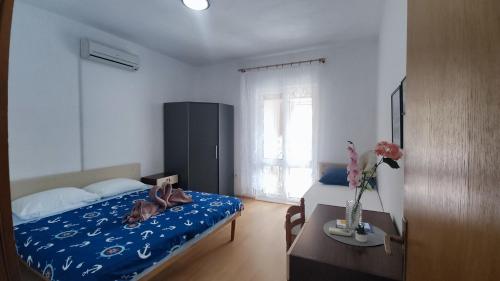 a bedroom with a bed and a table and a window at Villa Franić in Saplunara
