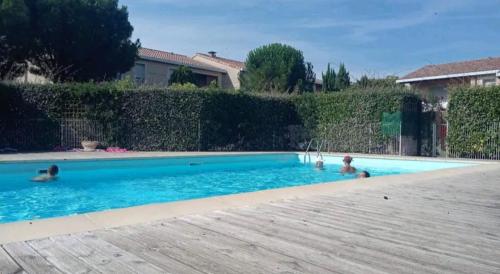 2 personnes nagent dans une piscine dans l'établissement Bienvenue à Carcassonne, à Carcassonne