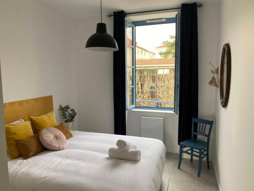 1 dormitorio con 1 cama, 1 silla y 1 ventana en Le Jules Appart'Hotel, en Romans-sur-Isère
