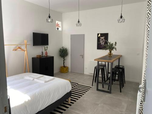 um quarto com uma cama, uma mesa e uma secretária em Le Jules Appart'Hotel em Romans-sur-Isère
