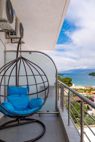 a chair on a balcony with a view of the ocean at Hotel Mira Mare in Ksamil