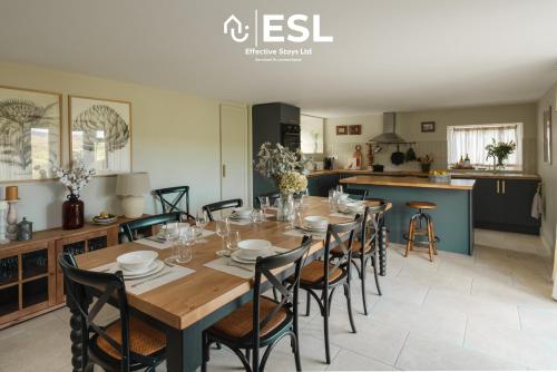 a dining room and kitchen with a table and chairs at Large Country Farmhouse with Hot Tub and Shropshire Hills View in Minsterley