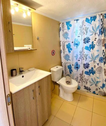 a bathroom with a toilet and a sink and a shower curtain at Jasmin Apartment Blue in Hanioti