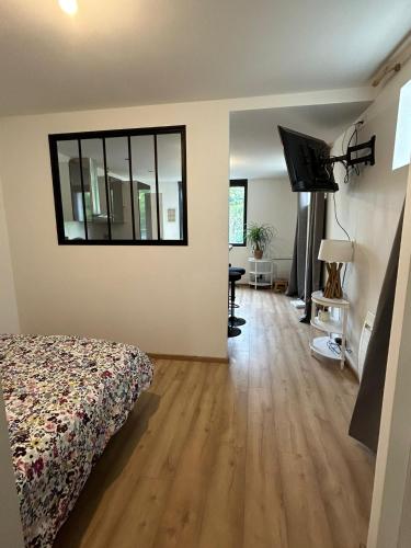 une chambre avec un lit et un miroir au mur dans l'établissement Studio CF Cosy Proche Gare, Centre Ville et Toutes Commodites, à Sainte-Savine
