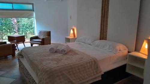 1 dormitorio con 1 cama con 2 zapatillas en Noah Housing en Santo Tomé