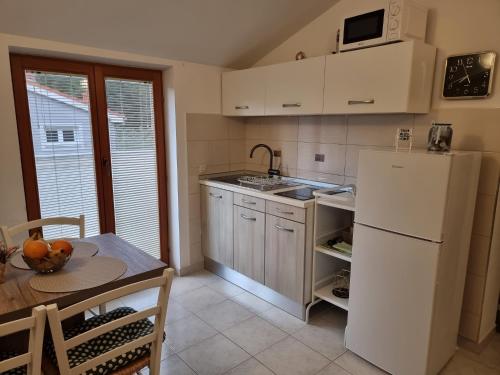 a kitchen with a white refrigerator and a table at Apartment Mango in Fažana