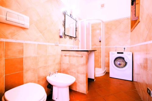 a bathroom with a toilet sink and a washing machine at Villacarrino in Positano