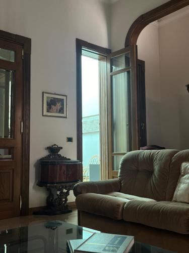 a living room with a couch and a glass table at Casa nel Liberty in Canicattini Bagni