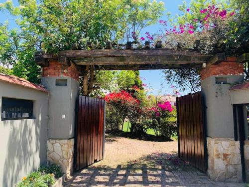 an entrance gate to a garden with flowers on top at Spain style country house in Cajica in Cajicá