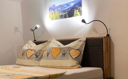 een slaapkamer met een bed met 2 kussens erop bij Alpen Appartements Oberlehengut - HIDEAWAY in Werfenweng