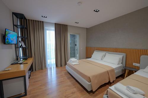 a hotel room with a bed and a television at Hotel Ajden by Mira Mare in Ksamil