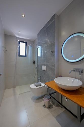 a bathroom with a sink and a toilet and a mirror at Hotel Ajden by Mira Mare in Ksamil