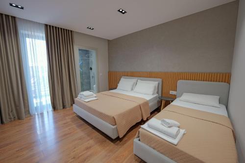 a hotel room with two beds and a window at Hotel Ajden by Mira Mare in Ksamil
