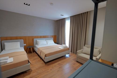 a hotel room with two beds and a mirror at Hotel Ajden by Mira Mare in Ksamil