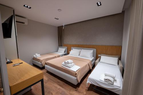 a small room with two beds and a table at Hotel Ajden by Mira Mare in Ksamil