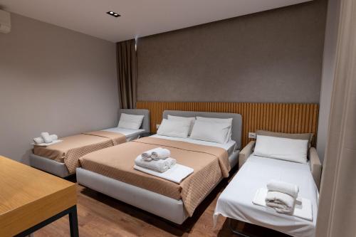 a room with two beds with towels on them at Hotel Ajden by Mira Mare in Ksamil