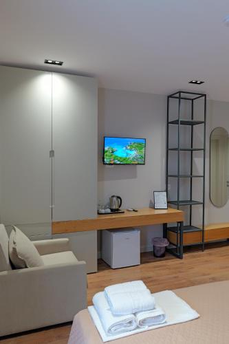 a living room with a couch and a tv on a wall at Hotel Ajden by Mira Mare in Ksamil