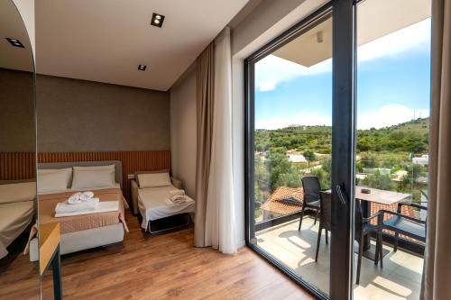 a bedroom with a bed and a balcony with a table at Hotel Ajden by Mira Mare in Ksamil