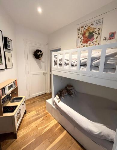 une chambre d'enfant avec un lit superposé et une cuisine dans l'établissement Charmant appartement familiale, à Paris