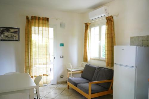 een woonkamer met een bank en een koelkast bij casaisoladelba immersa nel verde a 80mt dalla spiaggia in Lacona
