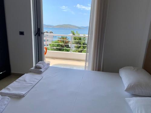 1 dormitorio con 1 cama y vistas al océano en Hotel Piazza, en Sarandë