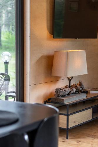 a table with a lamp on top of it at Jaunjespari 1 in Batciems