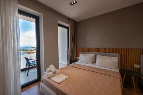 a bedroom with a bed and a large window at Hotel Ajden by Mira Mare in Ksamil