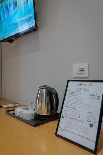 a sign on a table with a tea kettle on it at Hotel Ajden by Mira Mare in Ksamil