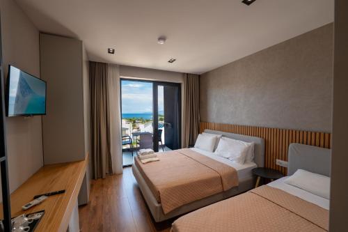 a hotel room with two beds and a television at Hotel Ajden by Mira Mare in Ksamil