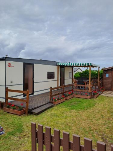 a tiny house with a deck and a patio at Mobil home inter in Berck-sur-Mer