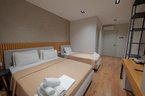 a small bedroom with two beds and a desk at Hotel Ajden by Mira Mare in Ksamil