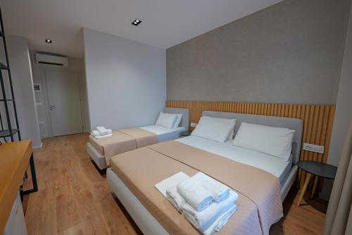 a bedroom with two beds with white towels on them at Hotel Ajden by Mira Mare in Ksamil