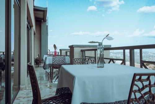 a table with a vase on top of a balcony at Mountain View Hotel & Apartment in Kigali