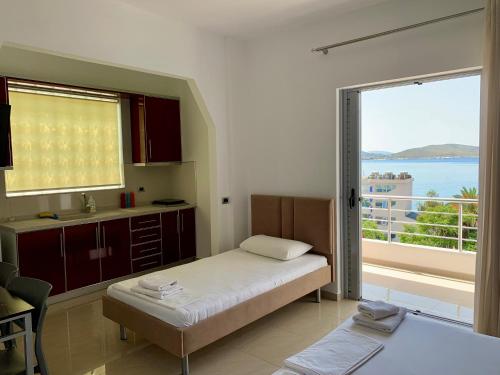 1 dormitorio con cama y vistas al océano en Hotel Piazza, en Sarandë