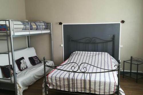 1 Schlafzimmer mit 2 Etagenbetten und 1 Bett mit einer Tagesdecke in der Unterkunft Gîte au cœur des châteaux de la loire in Lignières-de-Touraine